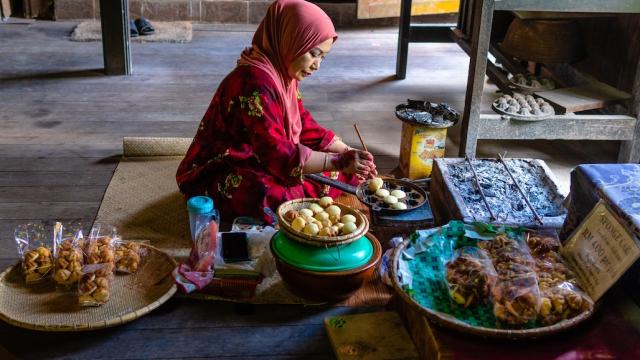 A woman cooking small cakes in Malaysia.