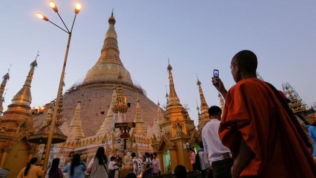 A Buddhist monk takes a picture of the Shwedagon Pagoda in Myanmar. Photo credit: ADB.